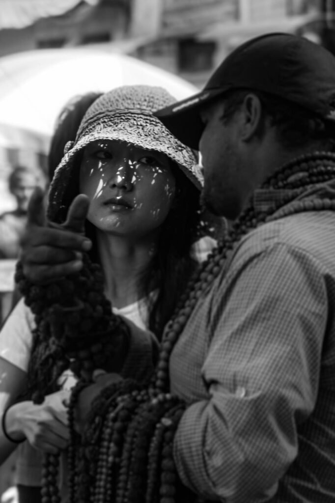 Chinese tourist looking to the souvenir seller.