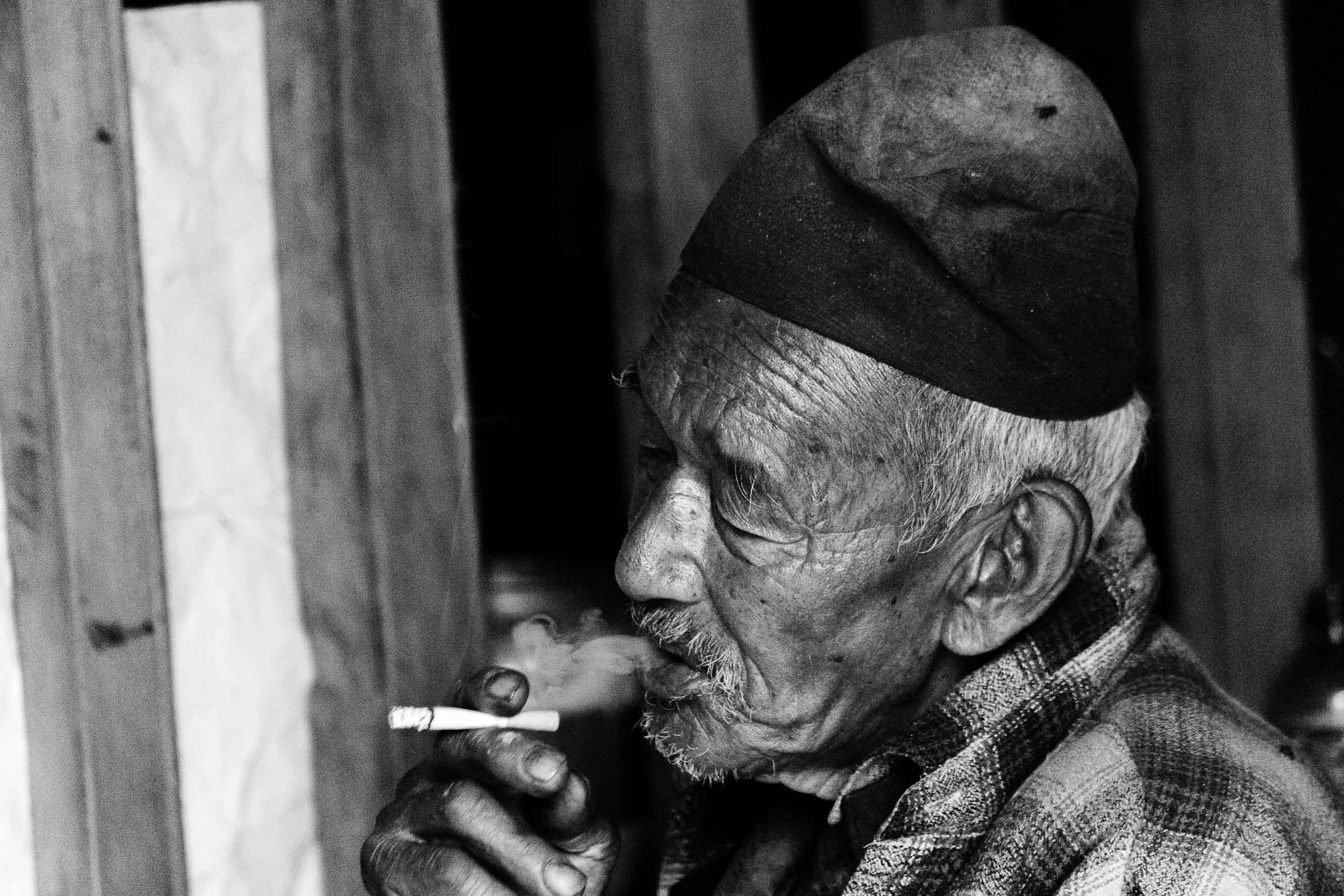 Black and White Portrait of an Elderly Man Smoking a Cigarette.