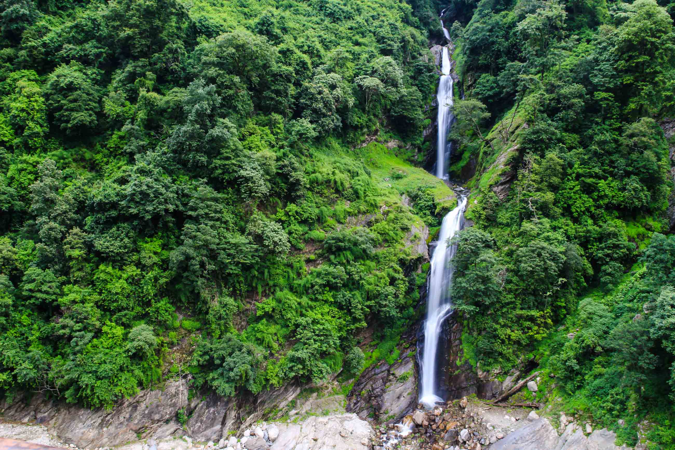 A Multi-Tiered Waterfall Cascading Through Dense Green Forest.